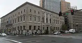 a three-story stone building on a street corner