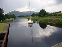 A sailing boat on the Caledonian Canal approaches from the Loch Linnhe side of the Mallaig Extension Railway swing bridge.