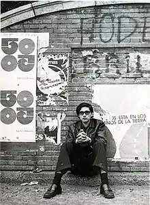 Carlos Mesa sits in front of a wall