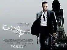 The poster shows Daniel Craig as James Bond, wearing a business suit with a loose tie and holding a gun. Behind him is a silhouette of a woman showing a building with a sign reading "Casino Royale" and a dark grey Aston Martin DBS below the building. At the bottom left of the image is the title "Casino Royale" – bothшп "O"s stand above each other, and below them is a 7 with a trigger and gun barrel, forming Bond's codename: "Agent 007" – and the credits.