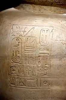 Large round vase of light brown stone inscribed with hieroglyphs