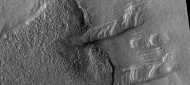 Remaining parts of a group of dipping layers.  Erosion has removed most of the material.