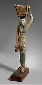 Figurine of a female servant carrying provisions; 1981–1975&nbsp;BC; painted wood and gesso; 112 × 17&nbsp;cm; Metropolitan Museum of Art (New York City)