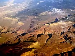 Aerial view – WNW of The Esplanade (Grand Canyon), south bank of Colorado River, with Toroweap Fault–(Prospect Canyon)  as west borderUinkaret volcanic field at NW; Lava Falls below in Colorado River