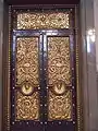 Bronze doors, designed by Cockerell, 12 feet (4&nbsp;m) 8 inches (20&nbsp;cm) high by 6 feet (2&nbsp;m) 4 inches (10&nbsp;cm) wide and weighs 74 cwt, there are three on each side of the hall, also three similar doors at the south end lead to the Crown Court and a smaller one is beneath the organ.
