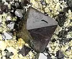 Octahedral crystals of magnetite up to 1.8&nbsp;cm across, on cream colored feldspar crystals, locality: Cerro Huañaquino, Potosí Department, Bolivia