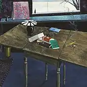 A table with books on the center and a lamp on the left.