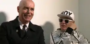 Two older men, one bald and one wearing a silver hat and sunglasses