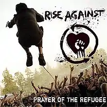 The back of a man is seen while he is jumping in front of a crowd. To the right of the man, there is a drawing of a fist in front of a heart, with the text "RISE AGAINST" above it. In the lower right corner, the text "PRAYER OF THE REFUGEE" is displayed.
