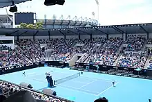 Show Court Arena during the 2023 Australian Open, with the Melbourne Cricket Ground visible in the background.