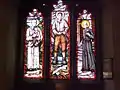 Stained glass west window depicting Óscar Romero, Pier Giorgio Frassati and André Bessette