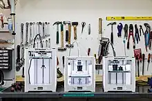 Tool board behind a desk with 3D printers