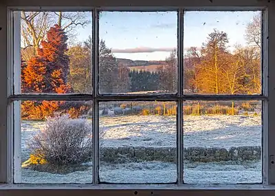 View of the Trossachs countryside through a farm window on a frosty evening