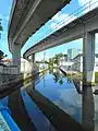 View of creek under Metrorail pylons from NW 11th Street bridge (view northwest)