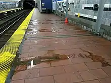 A station platform with several puddles of muddy water